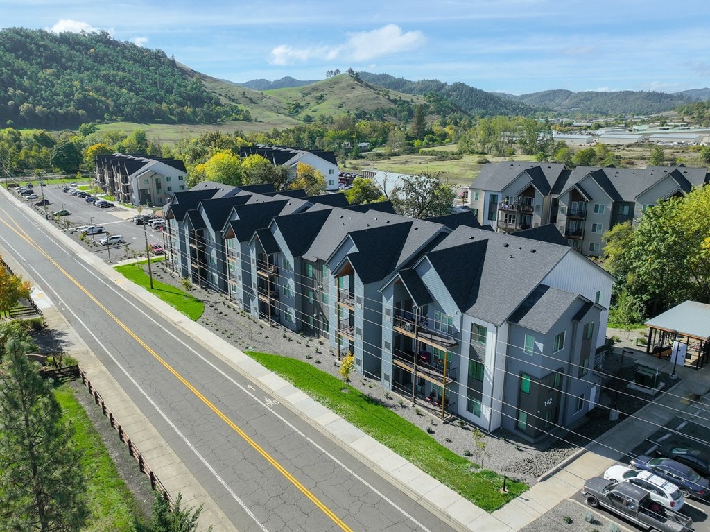 an aerial view of a row of houses with mountains in the background
