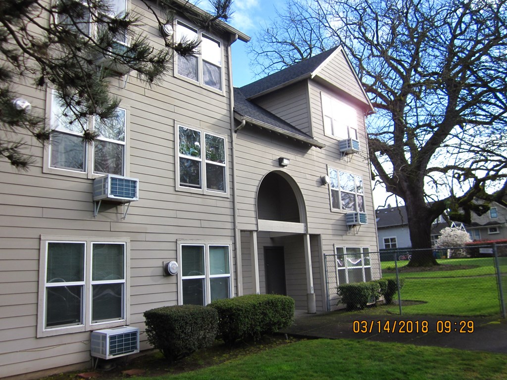 the outside of a house with a lawn and trees