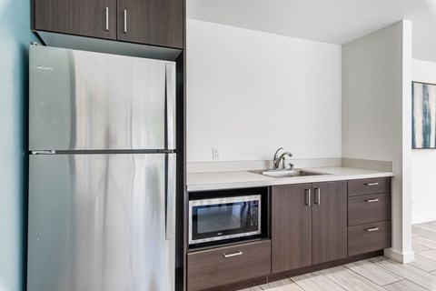a kitchen with a stainless steel refrigerator and a sink