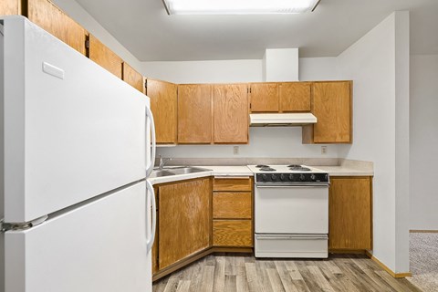 the preserve at ballantyne commons apartment kitchen with white appliances and wooden cabinets