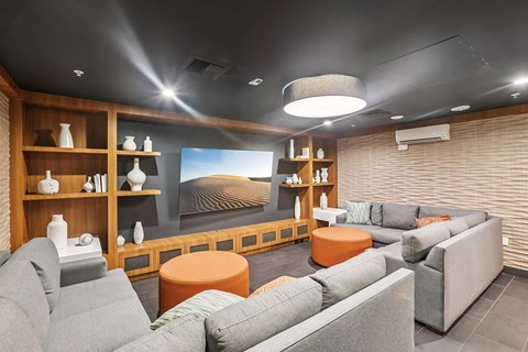 A modern living room with grey couches and a flat screen TV.