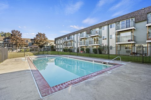 A swimming pool in front of apartment buildings.