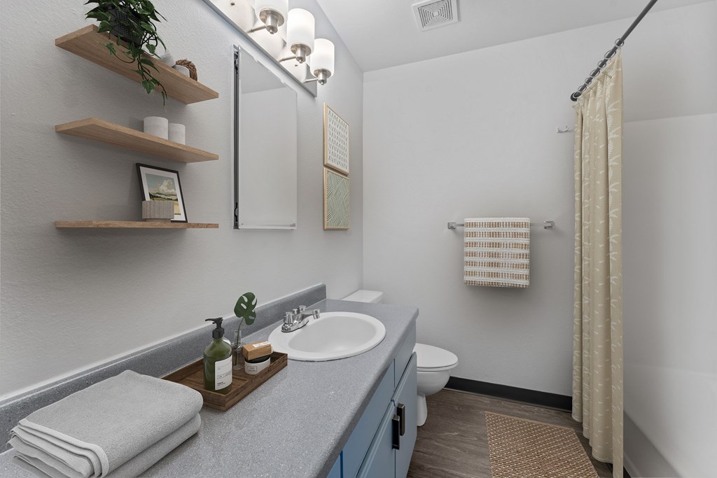 A bathroom with a white sink and a toilet.