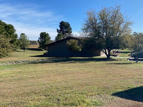A house is located in a field with trees.