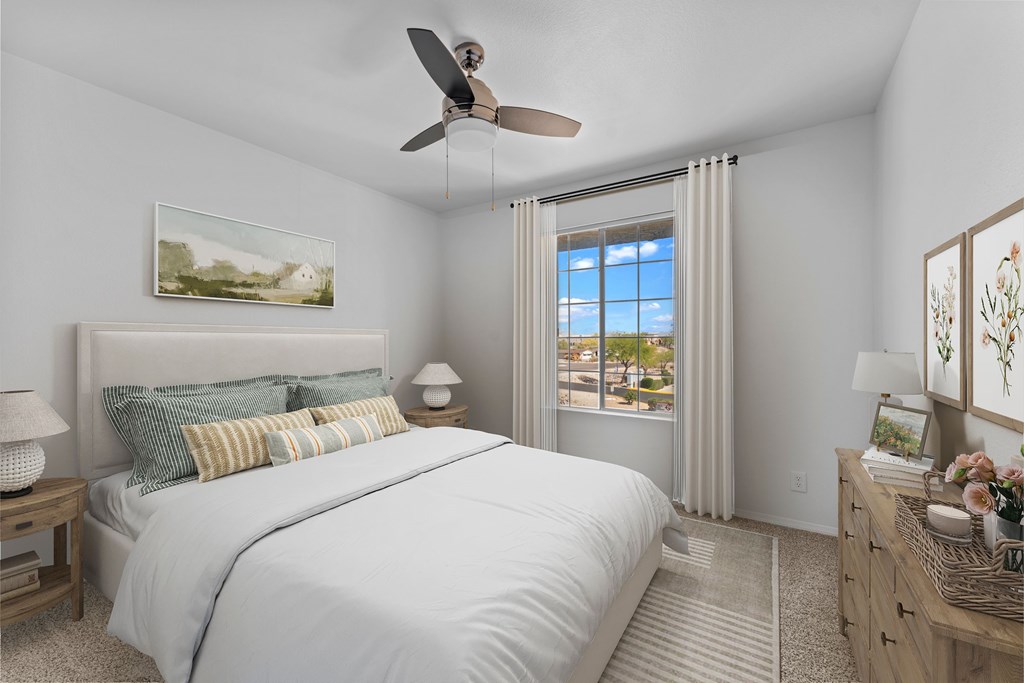 A bedroom with a large bed and a ceiling fan.