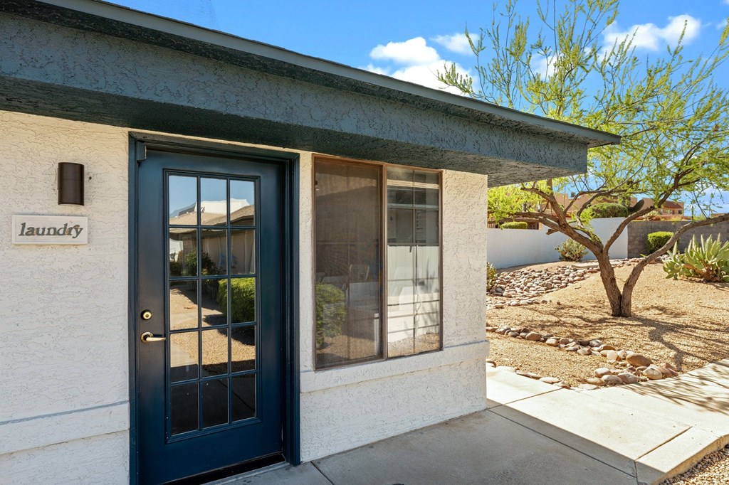 A house with a blue door and a sign that says "laundry" on the wall.