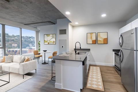 A modern kitchen with a large island and a view of the city.