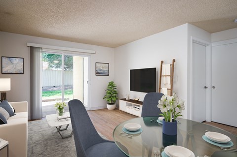 A modern living room with a glass table and grey chairs.