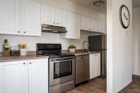 a kitchen with stainless steel appliances and white cabinets