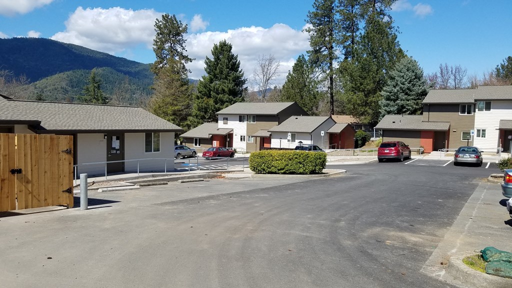 a neighborhood with houses and cars parked in a parking lot