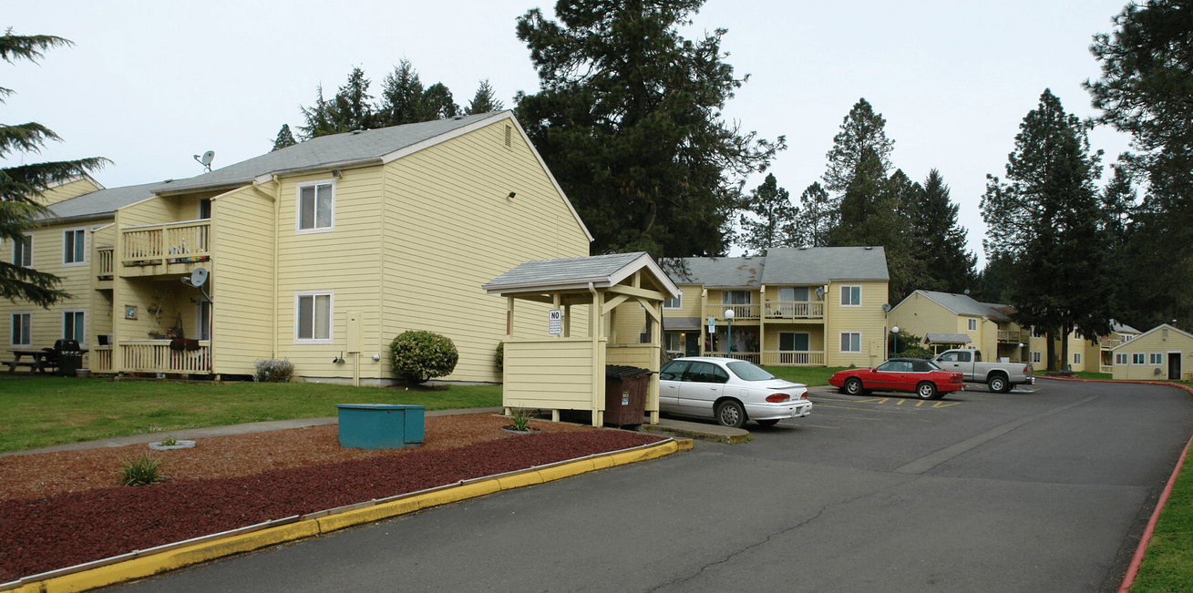a parking lot with cars in front of apartment buildings