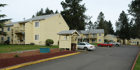 a parking lot with cars in front of apartment buildings