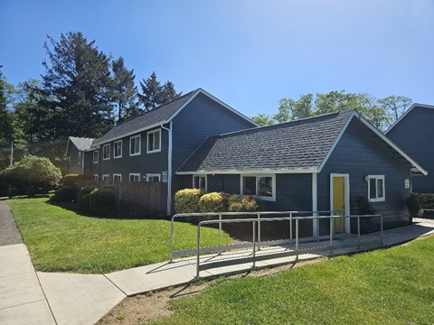 A blue house with a yellow door and a metal railing.