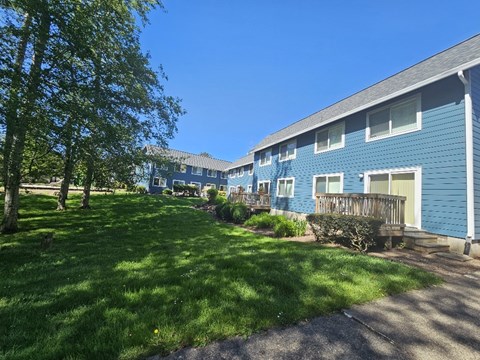 A blue building with a green lawn in front.