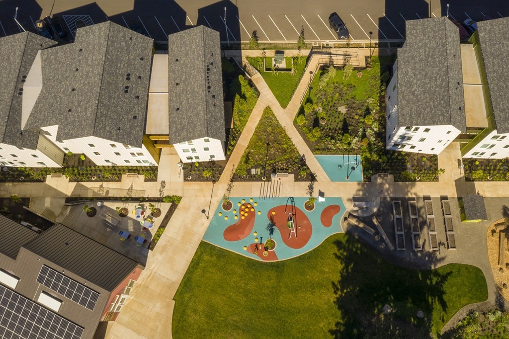 A playground with a slide and a green lawn.