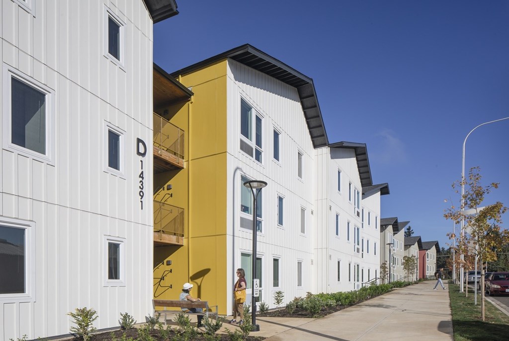 A white building with a yellow section in the middle of it.