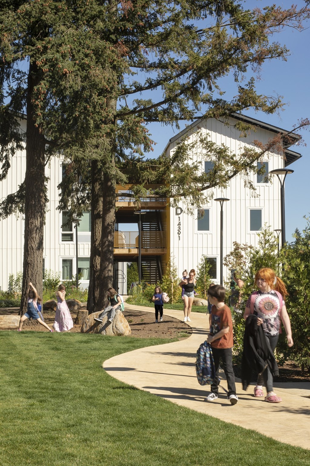 A white building with a tree in front of it.