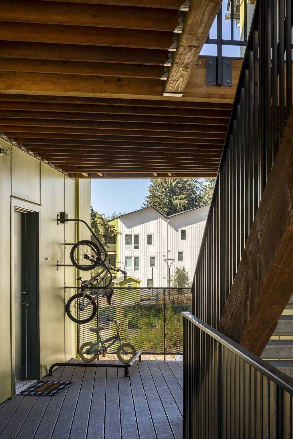 A bicycle is leaning against a wall on a wooden deck.