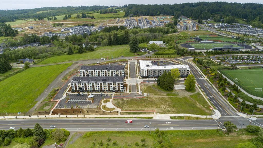 An aerial view of a large building complex with a parking lot in front.