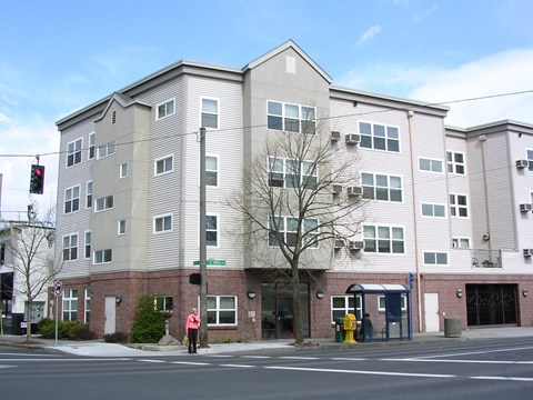 A grey building with a red fire hydrant in front of it.