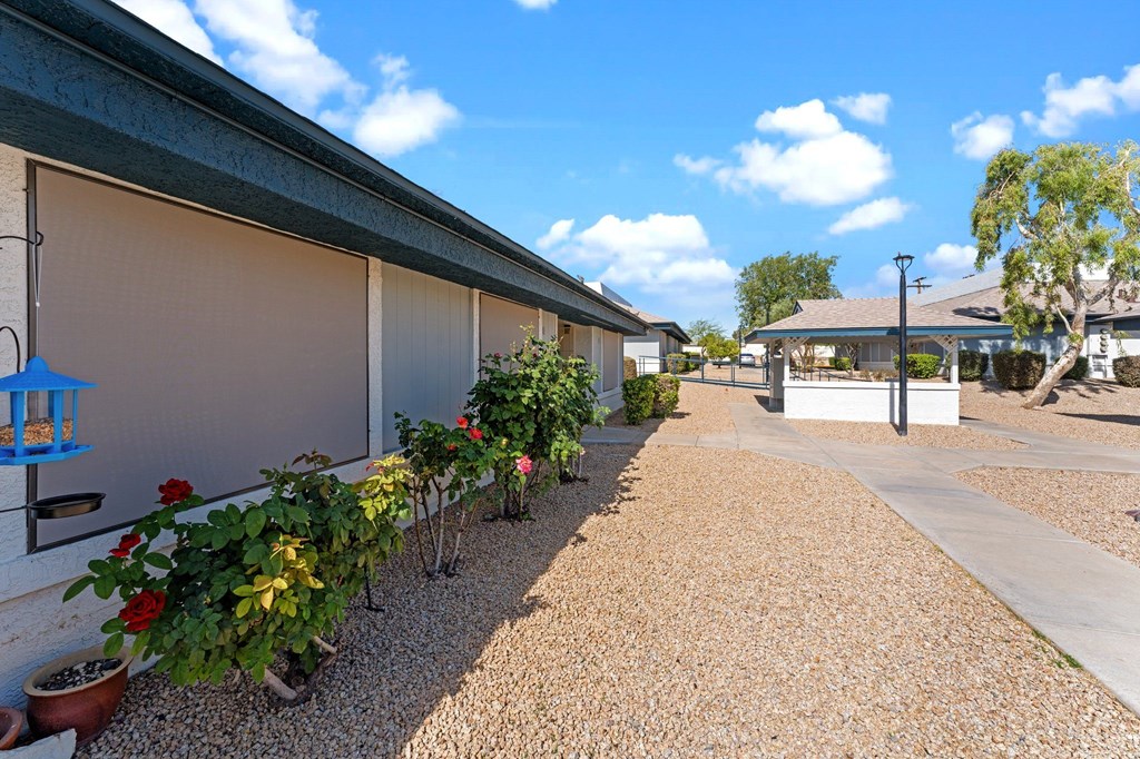 A gravel path leads to a building with a covered patio.