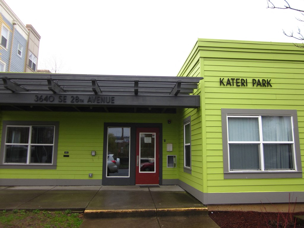 the building is painted yellow and green and has a red door