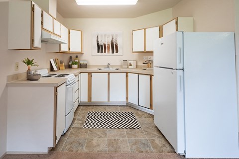 a kitchen with white appliances and a white refrigerator