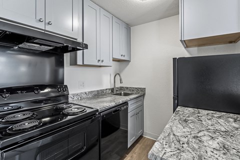 A kitchen with a black stove and white cabinets.