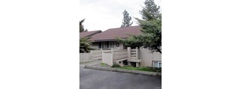 A house with a brown roof and a white fence.