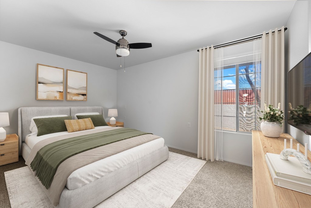 A bedroom with a bed, nightstand, and a window with a view of a city.