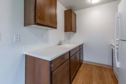 A kitchen with wooden cabinets and a white countertop.