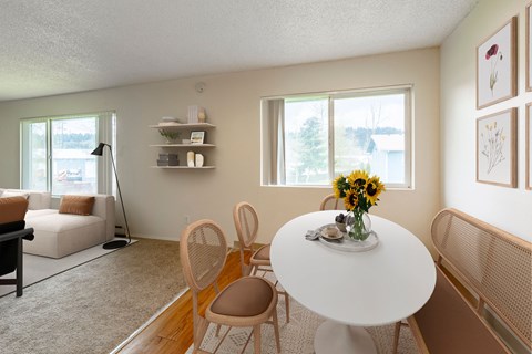 A dining room with a white table and chairs.
