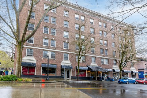 A large brick building with a red awning in front.