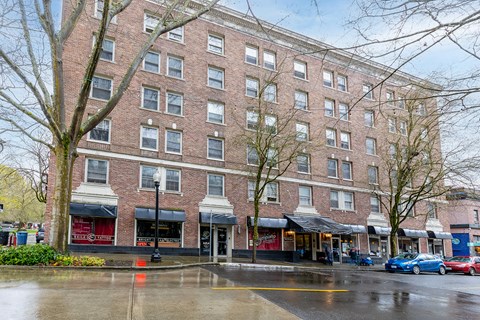 A large brick building with a red awning in front.