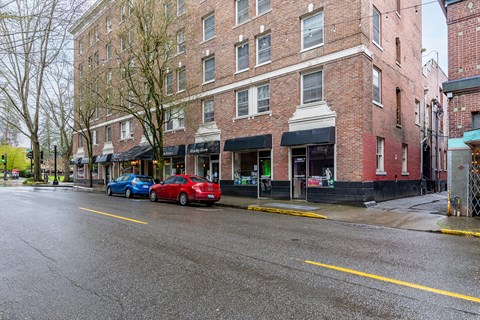 A red car is parked on the side of the street.