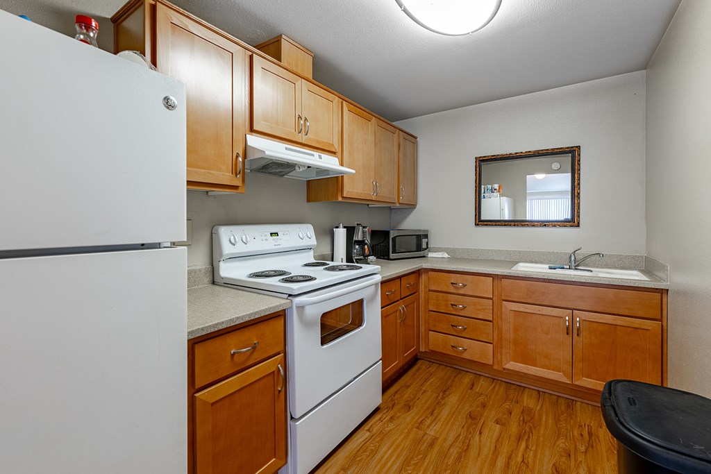 A kitchen with wooden cabinets and a white refrigerator.