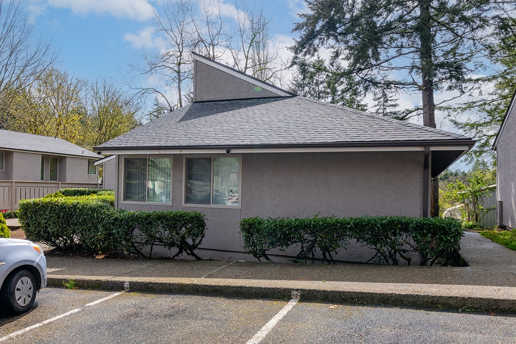 A grey house with a grey roof and a grey car parked in front.