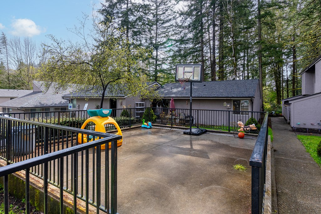 A yellow toy car is parked on a concrete driveway.