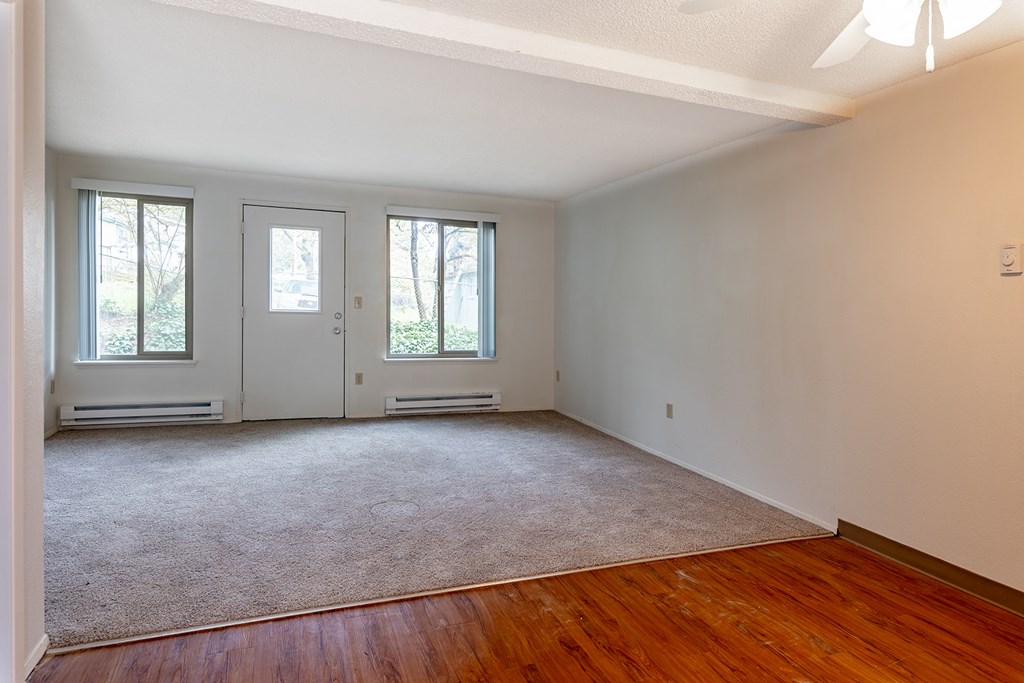 A room with a carpeted floor and a white wall.