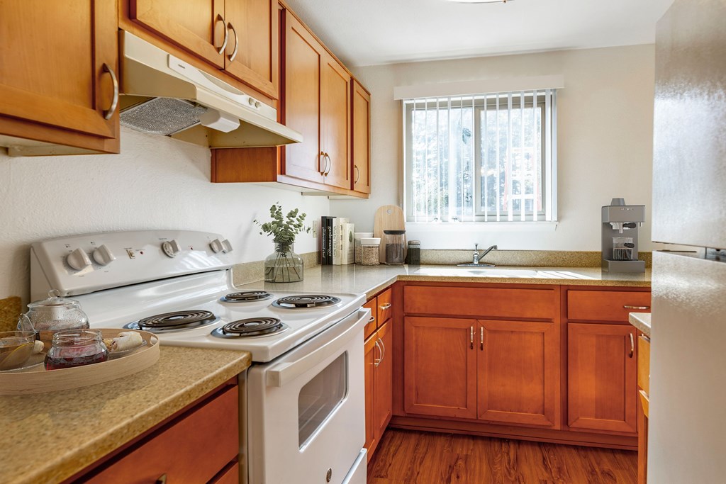 A kitchen with wooden cabinets and a white stove top.