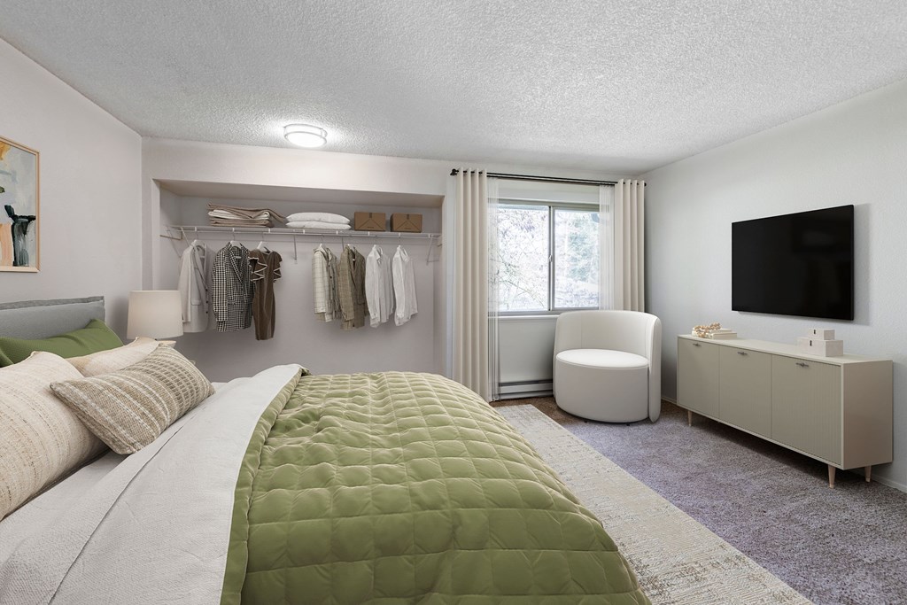 A bedroom with a large bed and a green comforter.