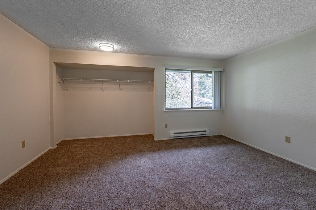 A room with a carpeted floor and a window.