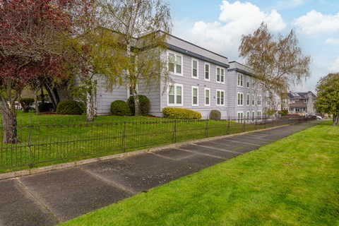 A long building with a fence in front of it.
