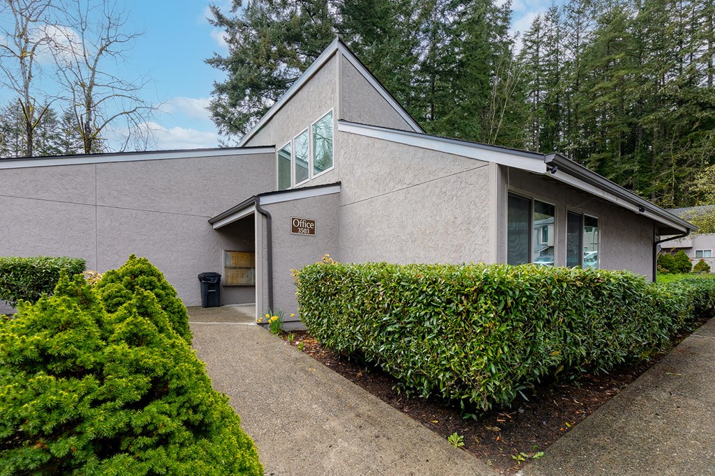 A grey building with a green sign on the front.