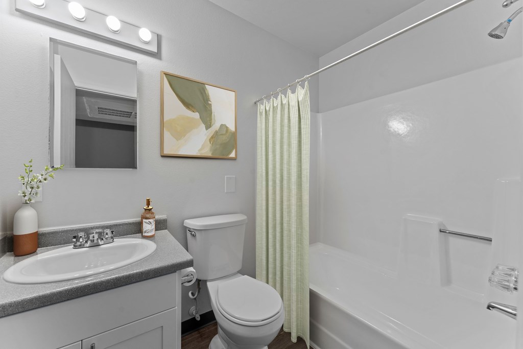 A bathroom with a toilet, sink, and bathtub.