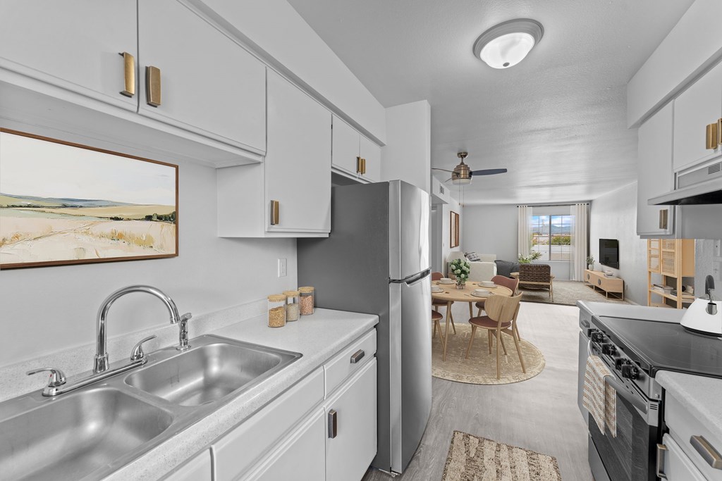 A kitchen with a stainless steel sink and refrigerator.