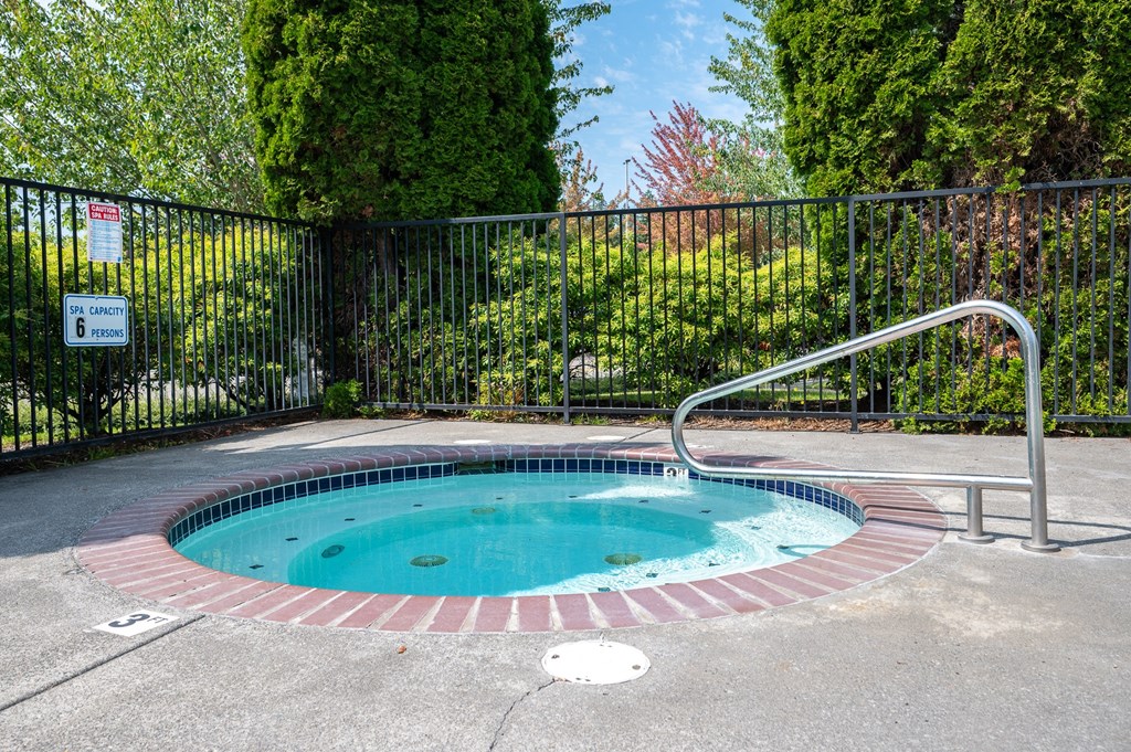 A small round pool with a metal fence around it.