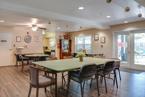A dining room with a green table and chairs.