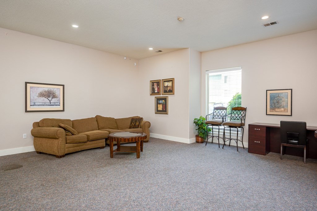 A living room with a couch, chair, and pictures on the wall.