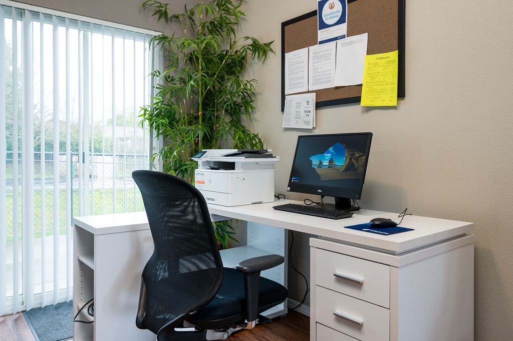 a desk with a computer and printer on it